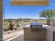 View of a built-in outdoor grill with stone countertops and desert landscaping at 14007 E Lupine Ave, Scottsdale, AZ 85259