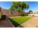 A low maintenance backyard with synthetic grass, desert landscaping, and privacy wall at 15456 W Corrine Dr, Surprise, AZ 85379