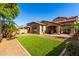 A view of the backyard with a synthetic grass area and desert landscaping with privacy at 15456 W Corrine Dr, Surprise, AZ 85379
