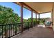 Inviting covered balcony with decorative columns, a black metal railing, and an outdoor seating area at 15456 W Corrine Dr, Surprise, AZ 85379