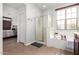 Bathroom featuring a tub with a shower, vanity, and view into the main bedroom at 15456 W Corrine Dr, Surprise, AZ 85379