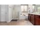 Well-lit bathroom features a double sink vanity, stand alone shower, and window at 15456 W Corrine Dr, Surprise, AZ 85379