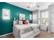 Cozy bedroom with teal walls, a white bedframe, and plush bedding, creating a relaxing retreat at 15456 W Corrine Dr, Surprise, AZ 85379