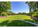 A large community green is surrounded by landscaping, brick walls, flowers, and trees at 15456 W Corrine Dr, Surprise, AZ 85379