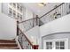Grand foyer boasts high ceilings, staircase with wood and iron railing, and decorative wall art at 15456 W Corrine Dr, Surprise, AZ 85379