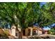 Charming home with a welcoming front porch and a second-story balcony, framed by mature trees at 15456 W Corrine Dr, Surprise, AZ 85379
