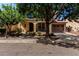 Charming home with mature trees, a front porch, and a two-car garage at 15456 W Corrine Dr, Surprise, AZ 85379