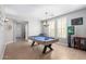 Well-lit game room features a pool table and plantation shutters for natural light at 15456 W Corrine Dr, Surprise, AZ 85379