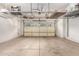 Clean garage with overhead storage and an insulated garage door at 15456 W Corrine Dr, Surprise, AZ 85379