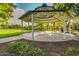 A gazebo in a community park sits on a large concrete pad surrounded by landscaped greenery and trees at 15456 W Corrine Dr, Surprise, AZ 85379