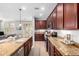Gourmet kitchen with an island, granite counters, dark wood cabinetry, and stainless steel appliances at 15456 W Corrine Dr, Surprise, AZ 85379