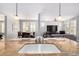 Open kitchen featuring an island with a sink that overlooks the dining and living areas at 15456 W Corrine Dr, Surprise, AZ 85379