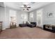 Bright living room with shutters, ceiling fan, and gray sectional sofa, creating a comfortable and inviting space at 15456 W Corrine Dr, Surprise, AZ 85379