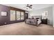 Large primary bedroom features a ceiling fan, neutral carpet, and large windows for natural light at 15456 W Corrine Dr, Surprise, AZ 85379