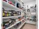 Walk-in pantry with ample shelving for storage of food and household items at 15456 W Corrine Dr, Surprise, AZ 85379