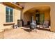 Outdoor patio with a fire pit, seating area, and arched entrance at 15456 W Corrine Dr, Surprise, AZ 85379