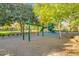 A colorful playground with slides and climbing structures sits atop a bed of sand and sits near mature shade trees at 15456 W Corrine Dr, Surprise, AZ 85379