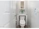 This powder room features an elongated toilet with white walls and built in toilet paper holder at 15456 W Corrine Dr, Surprise, AZ 85379