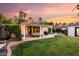 A backyard covered patio with seating and well-maintained green grass with lush landscaping at 1625 N 11Th Ave, Phoenix, AZ 85007