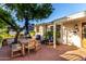 Brick patio with wooden table and seating, set amidst lush greenery, creates an inviting outdoor space at 1625 N 11Th Ave, Phoenix, AZ 85007