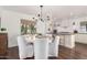 Dining area with a round table, white chairs, a modern chandelier, and an open view to the kitchen at 1625 N 11Th Ave, Phoenix, AZ 85007