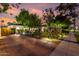 Well-lit home with a brick driveway, green lawn, and blossoming bushes enhancing the curb appeal at 1625 N 11Th Ave, Phoenix, AZ 85007