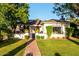 Charming single story home with lush front lawn and mature trees lining a brick walkway at 1625 N 11Th Ave, Phoenix, AZ 85007