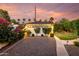 Charming garage adorned with lush flowers and a gravel driveway, all set against a vibrant sunset backdrop at 1625 N 11Th Ave, Phoenix, AZ 85007