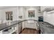 Bright kitchen features white cabinets, a farm sink, dark stone countertops, and hardwood flooring at 1625 N 11Th Ave, Phoenix, AZ 85007