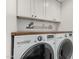 Bright laundry room with front loading washer, dryer, wood countertop and cabinets at 1625 N 11Th Ave, Phoenix, AZ 85007