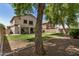 Spacious backyard with green grass, patio, bbq and mature trees offers serene outdoor living at 16386 W Sierra St, Surprise, AZ 85388