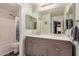 Well-lit bathroom features a double vanity with gray cabinets and a shower-tub combo at 16386 W Sierra St, Surprise, AZ 85388