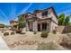 Inviting two-story home features a covered porch, desert landscaping, neutral stucco and stylish grey accents at 16386 W Sierra St, Surprise, AZ 85388