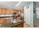 Updated kitchen with stainless steel appliances, granite countertops, and natural wood cabinetry at 16386 W Sierra St, Surprise, AZ 85388