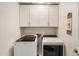 Modern laundry room featuring new front load washer and dryer with white cabinets at 16386 W Sierra St, Surprise, AZ 85388