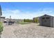 Spacious backyard featuring a storage shed, pavers and turf at 16617 W Desert Mirage Dr, Surprise, AZ 85388