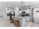 Modern kitchen features white cabinets, stainless steel appliances, and a granite island with seating at 16617 W Desert Mirage Dr, Surprise, AZ 85388