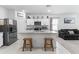 Modern kitchen features white cabinets, stainless steel appliances, and a granite island with seating at 16617 W Desert Mirage Dr, Surprise, AZ 85388