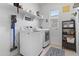 Well-lit laundry room featuring modern appliances, open shelving, and sleek decor at 16617 W Desert Mirage Dr, Surprise, AZ 85388