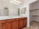 Bright bathroom featuring double sinks, vanity, and walk-in closet at 16813 S 30Th Ave, Phoenix, AZ 85045