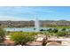 Scenic view of a lake with a water fountain surrounded by lush greenery, homes, and mountain views at 17214 E Alta Loma --, Fountain Hills, AZ 85268