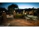 Patio with seating around an outdoor fireplace, illuminated by landscape lighting at nighttime at 17214 E Alta Loma --, Fountain Hills, AZ 85268