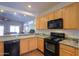 Bright kitchen showcases maple cabinets, granite countertops, and black appliances at 1880 E Birch St, Casa Grande, AZ 85122
