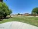 Sprawling backyard featuring a plush lawn, mature trees, and privacy fencing at 1898 N Hubbard Ln, Casa Grande, AZ 85122