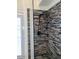 Detailed view of walk-in shower featuring custom tilework, river rock floor, and a showerhead at 1898 N Hubbard Ln, Casa Grande, AZ 85122