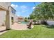 Serene backyard with a pool, patio, synthetic lawn, and mature trees at 19339 E Mockingbird Dr, Queen Creek, AZ 85142