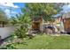 Beautiful backyard with treehouse, synthetic lawn, seating, lush tropical landscaping and BBQ at 19339 E Mockingbird Dr, Queen Creek, AZ 85142