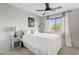 Bedroom with a ceiling fan, and a white bed complemented by a decorative side table at 19339 E Mockingbird Dr, Queen Creek, AZ 85142