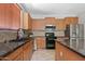 Well-lit kitchen featuring granite countertops, wooden cabinets, and stainless steel appliances at 19339 E Mockingbird Dr, Queen Creek, AZ 85142