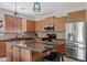 Kitchen with wood cabinets, stainless appliances, granite countertops, tile backsplash, and large island at 19339 E Mockingbird Dr, Queen Creek, AZ 85142